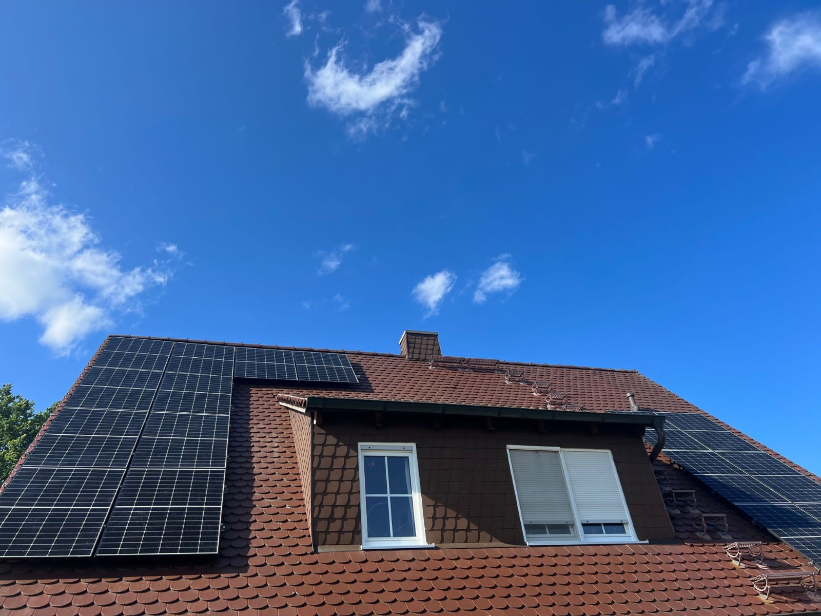 One Eco Solutions installiert eine moderne Photovoltaianlage auf einem Steildach mit Dachgaube auf Frankfurter Pfannen. Strom sparen durch grüne Energie.
